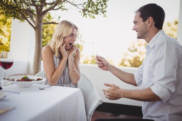 Man offering engagement ring to surprised woman