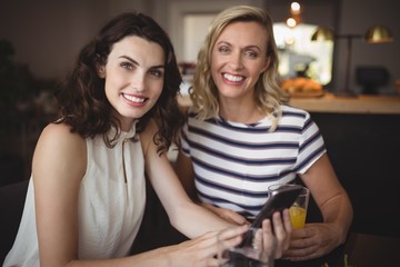 Portrait of two young women using mobile phone