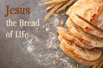 Sliced bread with wheat spikes and flour on grey table closeup