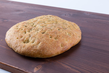 Focaccia italian flat bread with rosemary on an ipe natural wood table