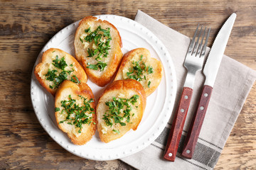 Tasty bread slices with garlic and herbs on plate