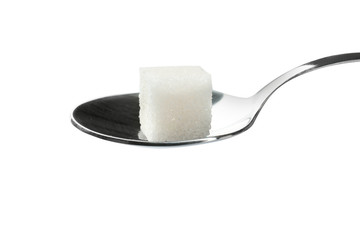 Sugar cube in spoon on white background