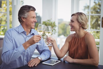 Couple toasting glasses of wine in restaurant