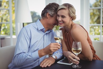 Couple interacting while having wine in restaurant