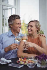 Couple toasting glasses of wine in restaurant