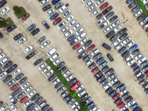 Aerial view full cars at large outdoor parking lots in Houston, Texas, USA. Outlet mall parking congestion and crowded parking lot with other cars try getting in and out, finding parking space.
