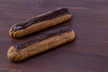 Two gorgeous parallel french eclairs on an ipe dark brown natural wood table
