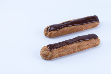 Two delicious parallel french chocolate eclairs  isolated in white background