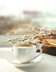 Ceramic cup with coffee on white window sill