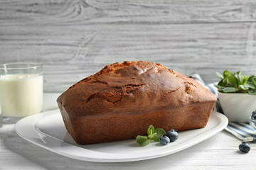 Plate with delicious freshly baked cake on table