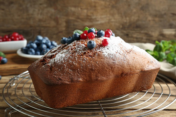 Delicious freshly baked cake with powdered sugar and berries on metal stand