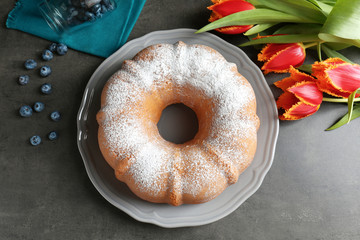 Plate with delicious freshly baked cake on table