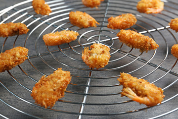 Cooling rack with delicious coconut shrimps, closeup
