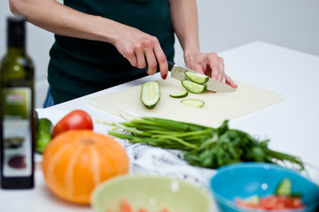 Obraz na płótnie Canvas Woman cutting vegetables in the kitchen