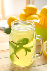 Delicious lemon juice in mason jar on wooden table
