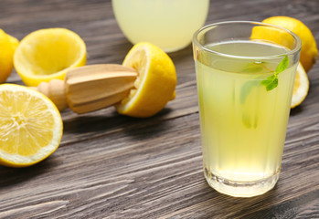 Delicious lemon juice in glass on wooden background
