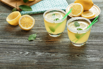 Glasses of lemon juice on wooden table