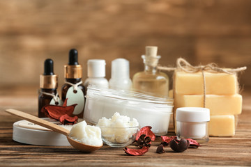 Composition of Shea butter with cosmetic products on wooden table