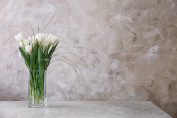 Vase with beautiful tulips on table
