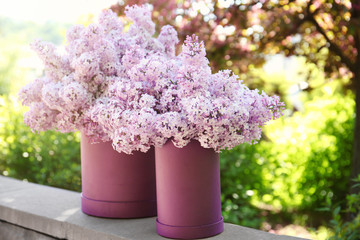 Packaging boxes with beautiful bouquet of lilac flowers, outdoors