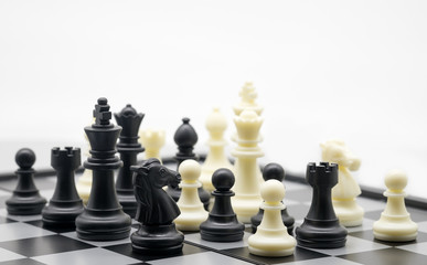 Chess figures black and white team on the chess board for competition; fighting; game; strategy concept.