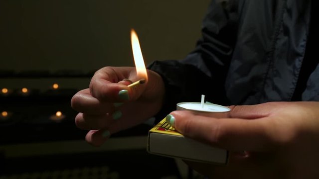 Young Woman Lights A Prayer Candle At The Oude Kerk (Old Church) In Amsterdam, Netherlands