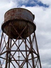 Rusty Water Tower Against Cloudy Sky