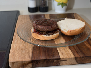 Hamburger on an opened bun with onions and ketchup