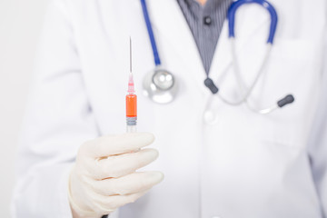 doctor and stethoscope holding syringe on white background