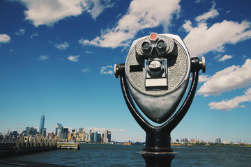 Pay binoculars in Hoboken, New Jersey with the Manhattan skyline in the background. Sunny summer...