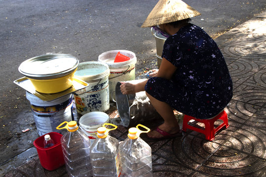 Women Washing dishes on the streets of Ho Chi Minh City in Saigon