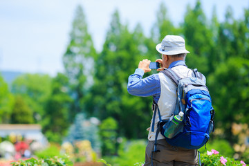 デジタルカメラを構える中高年男性旅行者