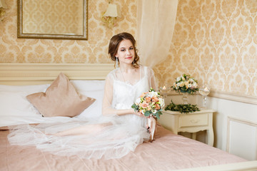 Pretty young Bride. Boudoir morning of the bride. Looking on her bouquet