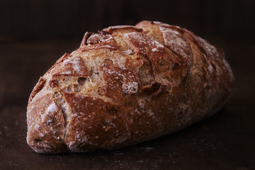 Walnut bread on dark wood background.