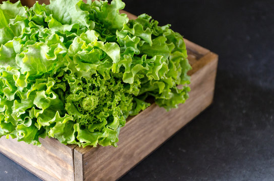 Lettuce in a wooden box on a dark marble background horizontally