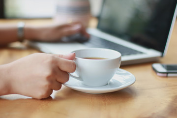 Close Up of woman hands using mobile phone and laptop computer with blank copy space screen for your advertising text message or content business in the Vintage effect.