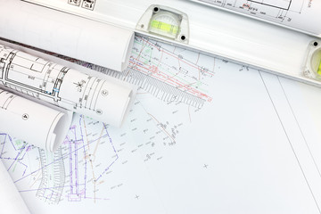 architect workplace with rolled plans, housing schemes and spirit level. top view
