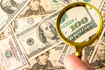 Hundred dollar bill under a magnifying glass 