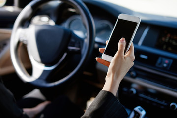 Woman in a car writing message on the phone
