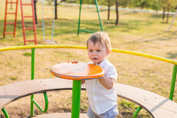 Cute young child boy or kid playing on playground.