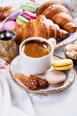 Breakfast with coffee, croissants and macarons