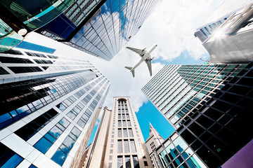 Airplane flying over business skyscrapers