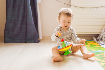 Cute child boy toddler playing with toy indoors