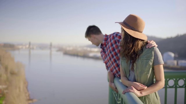 Couple Enjoy View Of Willamette River From St Johns Bridge (In Portland, Oregon) Man Kisses Girlfriend