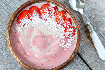 Bright summer strawberry-banana smoothie bowl with coconut. Love for a healthy vegan food concept