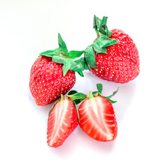 Cut and whole strawberries on white background