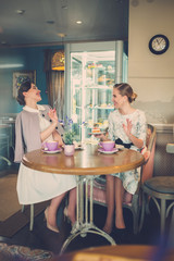 Two elegant young ladies in a cafe