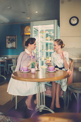 Two elegant young ladies in a cafe