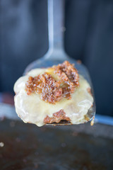 Cooked Beef Patty Covered in Melted Cheese on Spatula