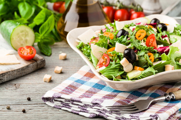 Italian salad with fresh vegetables with black olives and Parmesan cheese.